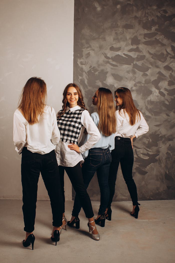 Four stylish women pose in a studio fashion shoot, highlighting trendy smart casual wear.